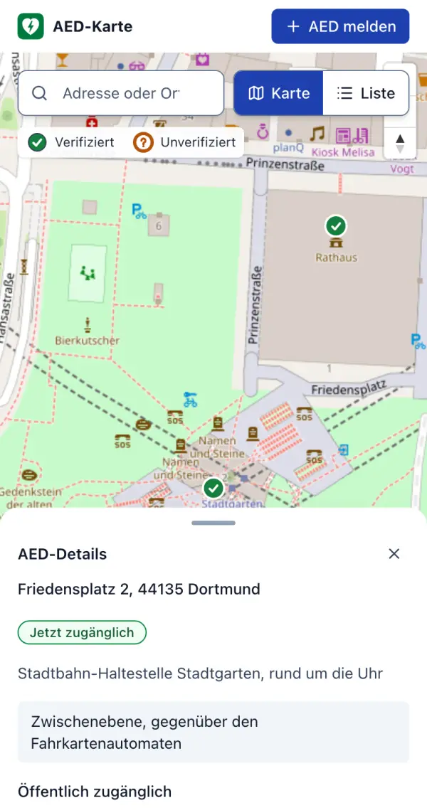 Die Karte auf dem Smartphone: Kartenausschnitt am Dortmunder Friedensplatz mit zwei verifizierten AED; darunter die Details des AED Friedensplatz 2 mit „Jetzt zugänglich“, „rund um die Uhr“, dem Hinweis „Zwischenebene, gegenüber den Fahrkartenautomaten“ und „Öffentlich zugänglich“.